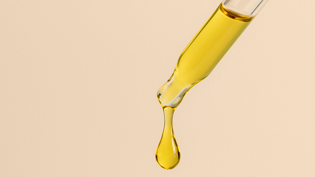 Pipettenspitze mit goldenem Pflegeöl was tropft