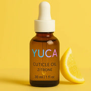 YUCA Cuticle Oil in einer 30 ml Braunglasflasche mit weißer Pipette, aufgestellt vor gelbem Hintergrund mit Zitronenscheibe – Nagelpflegeöl mit frischem Zitronenduft

